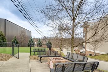 a patio with a fire pit and benches in front of a building at Residences at the Street, Washington, PA